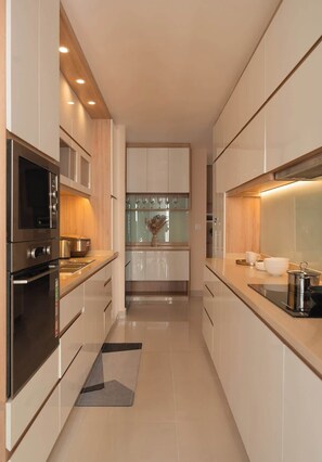 A modern kitchen with stainless steel appliances, wooden cabinets, and a central island. - 4BR · 5 Beds · 2BA · Fireworks/Bitexco View · D4 (Thành phố Hồ Chí Minh)
