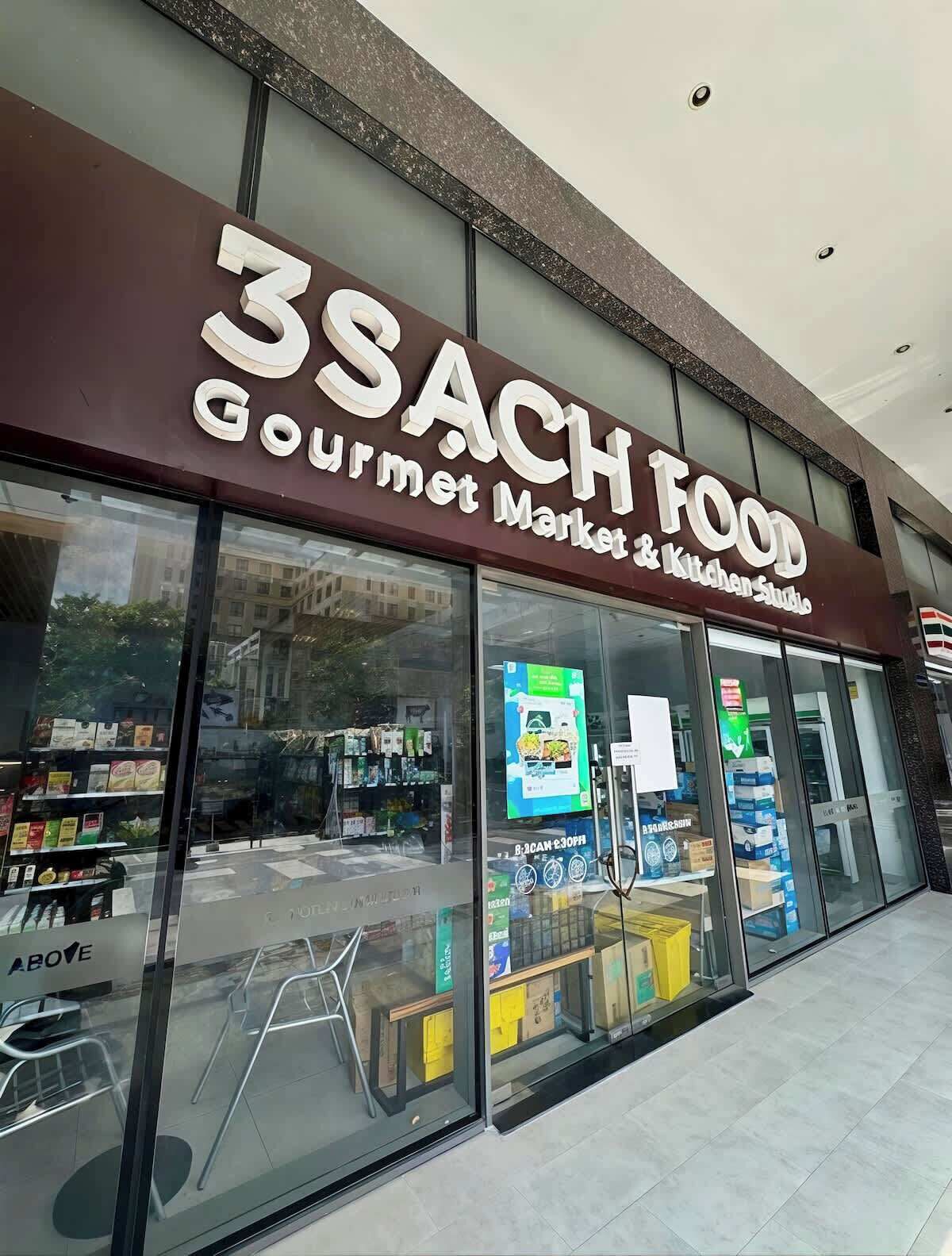 Ein Laden mit einem Schild, auf dem '3SACH FOOD Gourmet Market & Kitchen Studio' steht.
