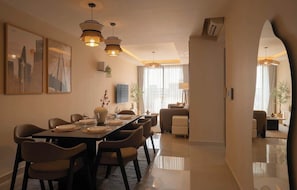 A modern dining area with a long table, multiple chairs, and pendant lighting. - 4BR · 5 Beds · 2BA · Fireworks/Bitexco View · D4 (Thành phố Hồ Chí Minh)