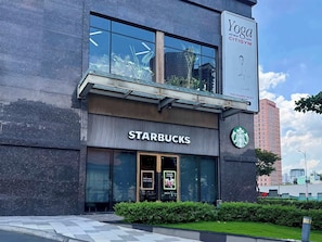 Ein Gebäude mit einem Starbucks-Geschäft und einem Schild für ein Yoga-Zentrum.
