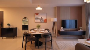 A modern living room with a dining area, a flat-screen TV, and a sofa. - Luxe 2BR+1BA | Central, 2 min BuiVien | D1, Tresor (Thành phố Hồ Chí Minh)