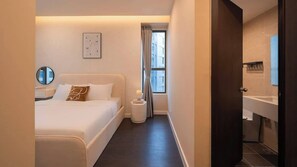 Ein Hotelzimmer mit Bett, Nachttisch und einem Vorhangfenster.