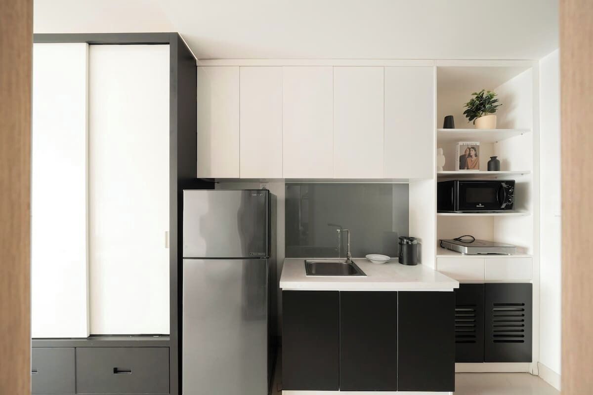 Une cuisine moderne équipée d’un réfrigérateur encastré, d’un four à micro-ondes et d’un évier.