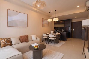 Ein modernes Wohnzimmer mit Sofa, Couchtisch und Essbereich.