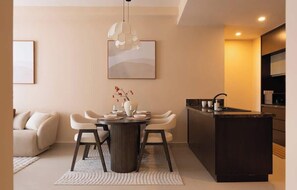 Ein modernes Interieur mit Essbereich, einer Couch, einer Kücheninsel und einer Pendelleuchte.