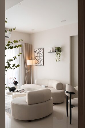 A modern living room with a sofa, a lamp, and a wall-mounted abstract art piece. - 2BR+3 Beds | 1BA • Central D1 • Walk to BuiVien (Thành phố Hồ Chí Minh)