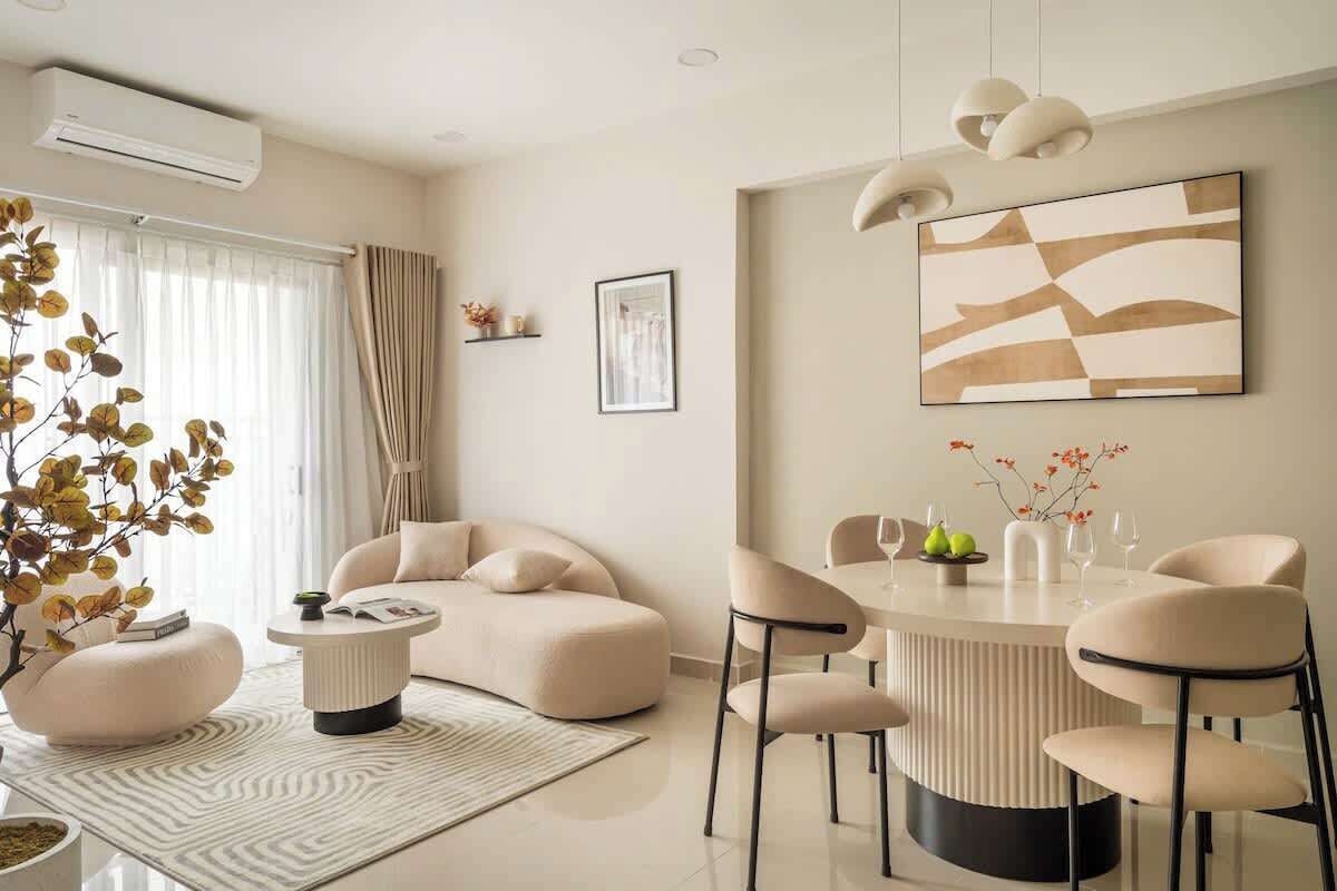A modern living room with a sofa, ottoman, coffee table, and a dining area with chairs and a table.