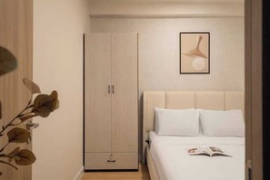 A bedroom with a bed, a wardrobe, and a framed picture on the wall. - 2BR + 3 Beds | 1BA • Central D1 • Side River View (Thành phố Hồ Chí Minh)