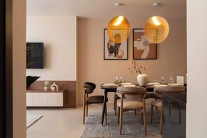 A dining area with a round table, chairs, and a vase with branches. - Luxury 3BR 2BA | Central | 2 min BuiVien | D1 (Thành phố Hồ Chí Minh)