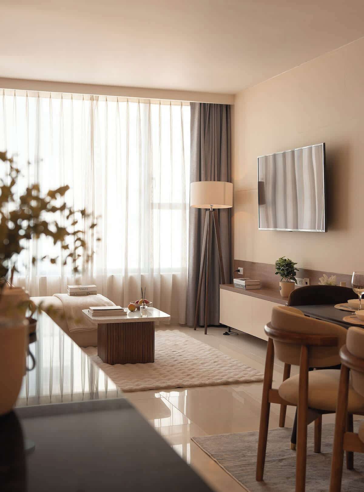En moderne stue med sofa, sofabord og et spiseområde med stole.