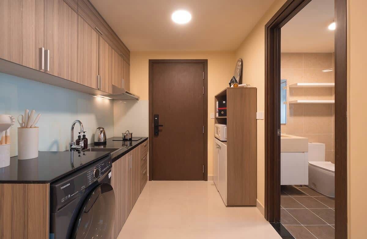 Eine kleine Küche mit Waschmaschine, Mikrowelle und Schrank.