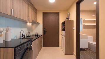 Eine kleine Küche mit Waschmaschine, Mikrowelle und Schrank.