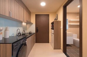 A compact kitchen with a washing machine, a microwave, and a cabinet. - Studio | Sofa Bed | Sleeps 4 | Near District 1 (Thành phố Hồ Chí Minh)