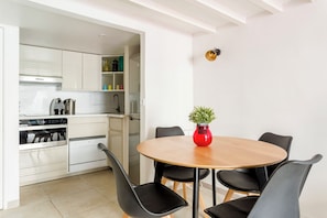 A compact kitchen with white cabinets, a built-in oven, and a coffee machine. - Charming apartment in the heart of le marais (Paris)