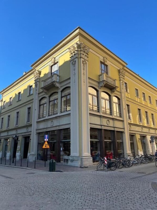 A yellow building with classical architecture, including columns and balconies. - Czeczotka Palace Apartments Old Town (Kraków)