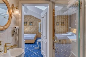 A hotel room with a large mirror, a bedside telephone, a bed with a blue patterned carpet, and a small table. - Czeczotka Palace Apartments Old Town (Kraków)