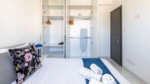A hotel room with a bed, a wardrobe, a mirror, and a door. - Platinum Breeze - 1-BR Apt. in Larnaca (Larnaka)