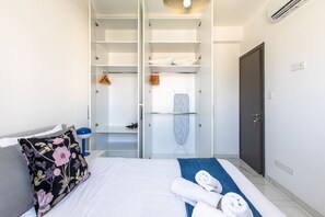 A hotel room with a bed, a wardrobe, a mirror, and a door. - Platinum Breeze - 1-BR Apt. in Larnaca (Larnaka)