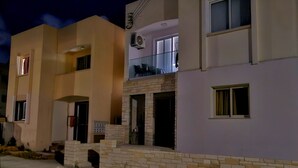 A residential building with a flat facade, a brick entrance, and a balcony with outdoor furniture. - Studio in the heart of Paphos (Pafos)