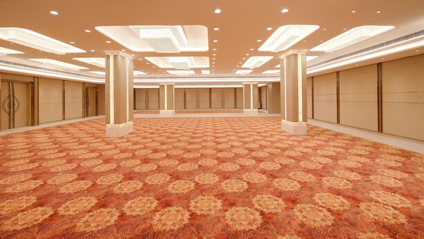 A spacious hotel room with a patterned carpet, recessed lighting, and a symmetrical layout. -  Lemon Tree Hotel, Bharuch (Bharuch)