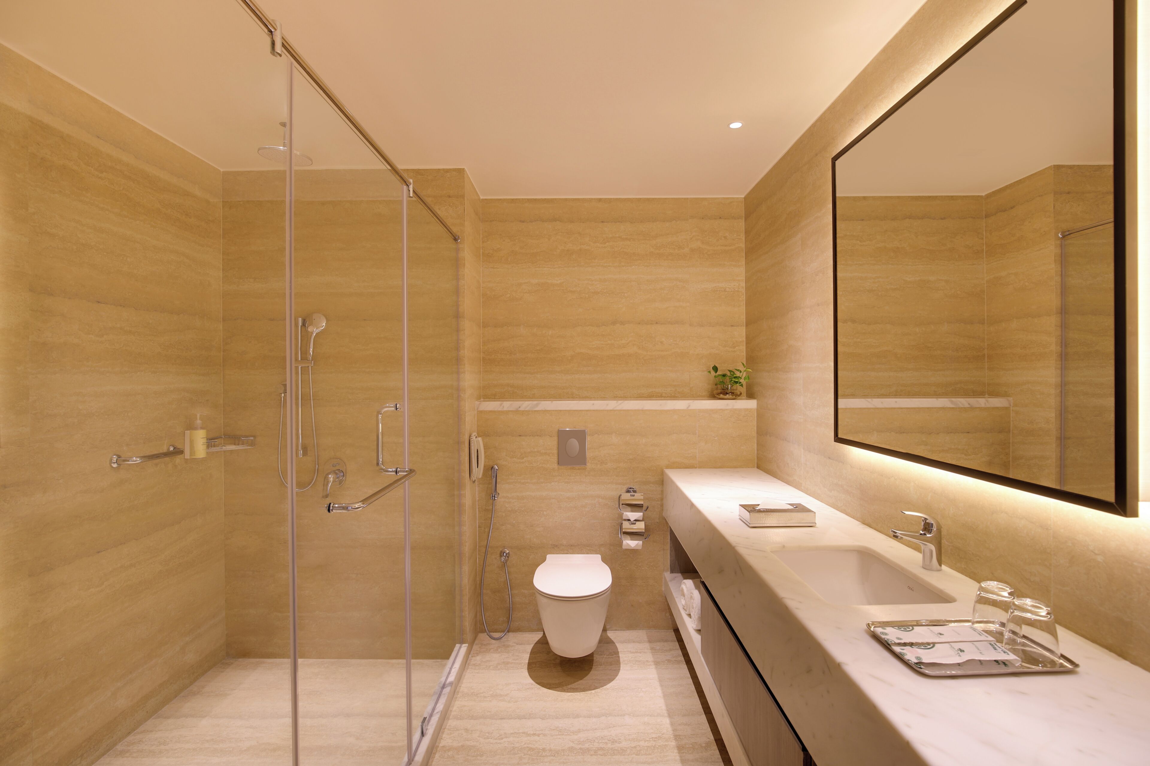 A modern bathroom with a glass-enclosed shower, a toilet, and a vanity with a mirror.