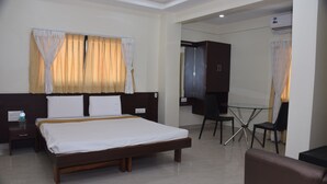 Une chambre d’hôtel avec un lit, un bureau et une chaise.