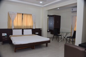 Quarto de hotel com uma cama, uma secretária e uma cadeira.