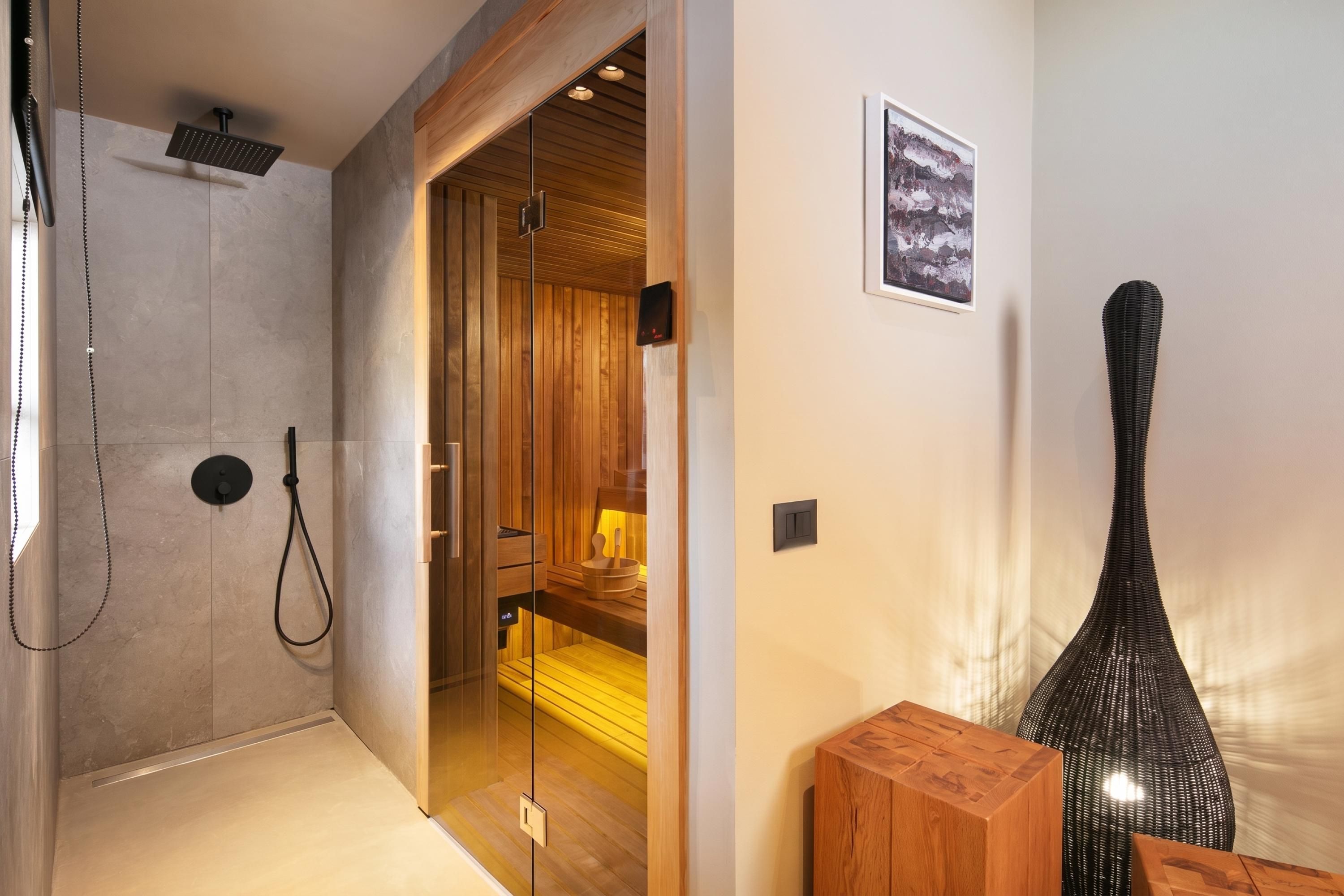 A modern bathroom with a glass shower enclosure, wooden accents, and a minimalist design.