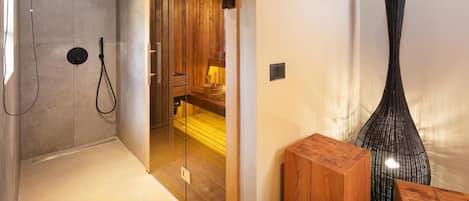 A modern bathroom with a glass shower enclosure, wooden accents, and a minimalist design.