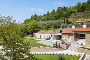 A modern house with a swimming pool, outdoor seating, and a view of the surrounding hills. - Villa Panorama Del Tartufo (Buzet)