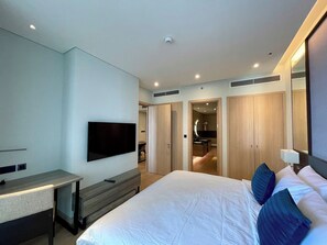Ein Hotelzimmer mit Bett, Schreibtisch, Fernseher und Kleiderschrank.