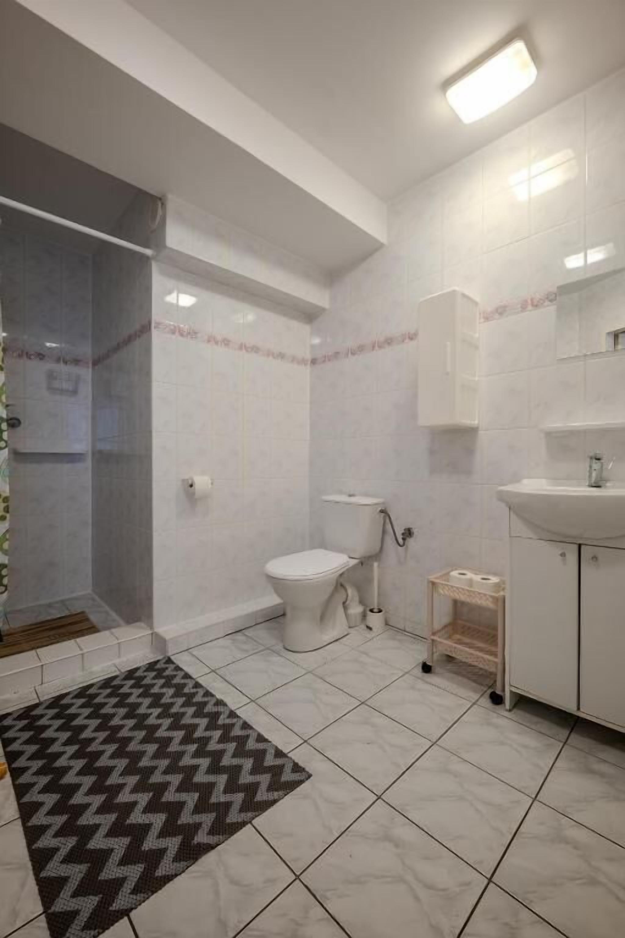 A bathroom with a shower, toilet, and sink.