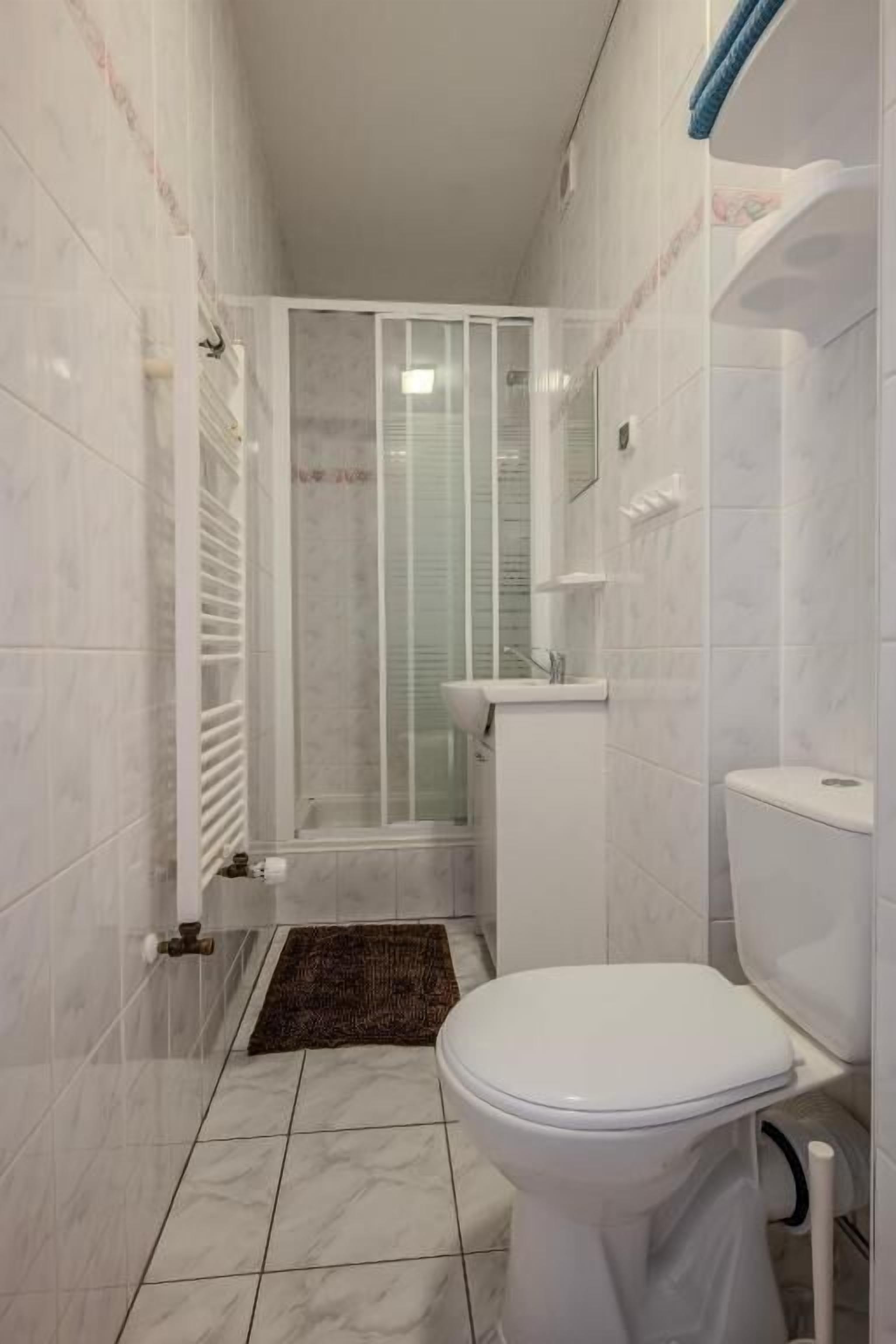 Un bagno con un WC, uno spazio doccia e un lavandino.