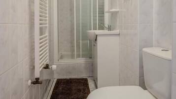 Un bagno con un WC, uno spazio doccia e un lavandino.