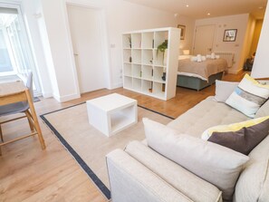 Ein modernes Wohnzimmer mit einer Couch, einem Couchtisch und einem weißen Bücherregal.