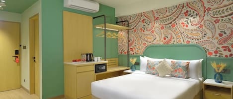 Una habitación de hotel con cama, mesitas de noche, armario, equipo de aire acondicionado y un papel tapiz estampado.