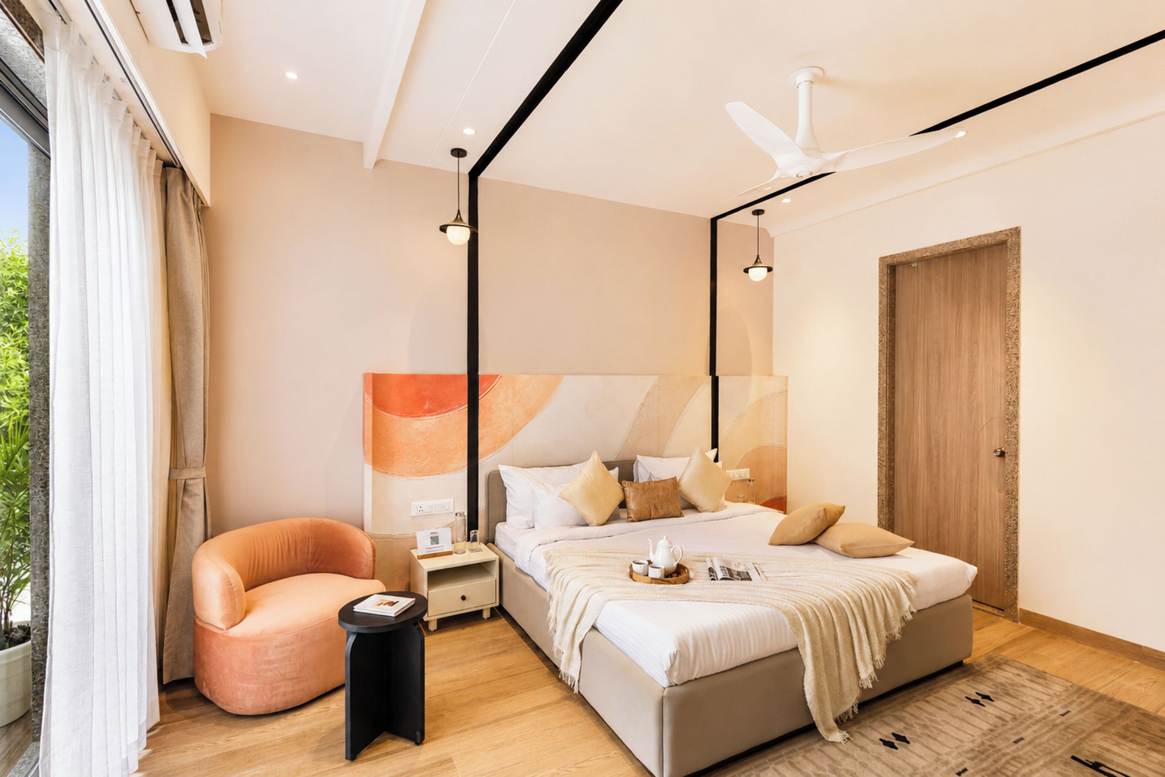 Een moderne slaapkamer met een bed, een stoel, een nachtkastje en een grote spiegel.