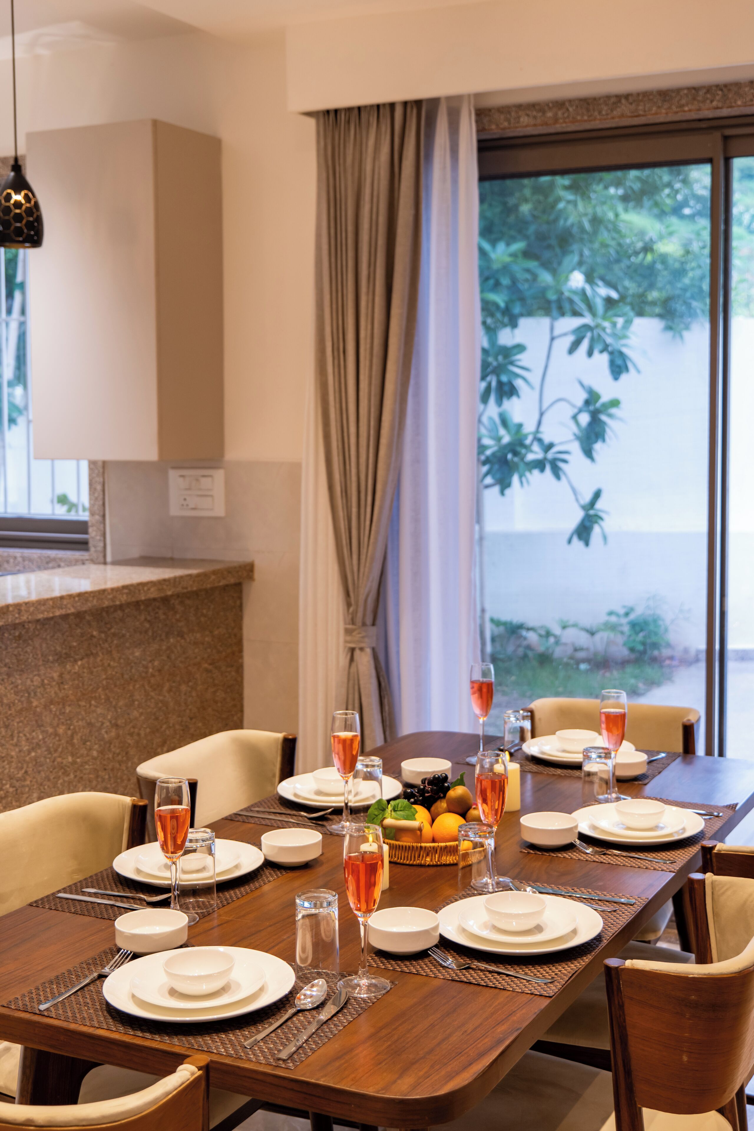 Une table à manger dressée pour un repas, avec des assiettes, des verres et des couverts.