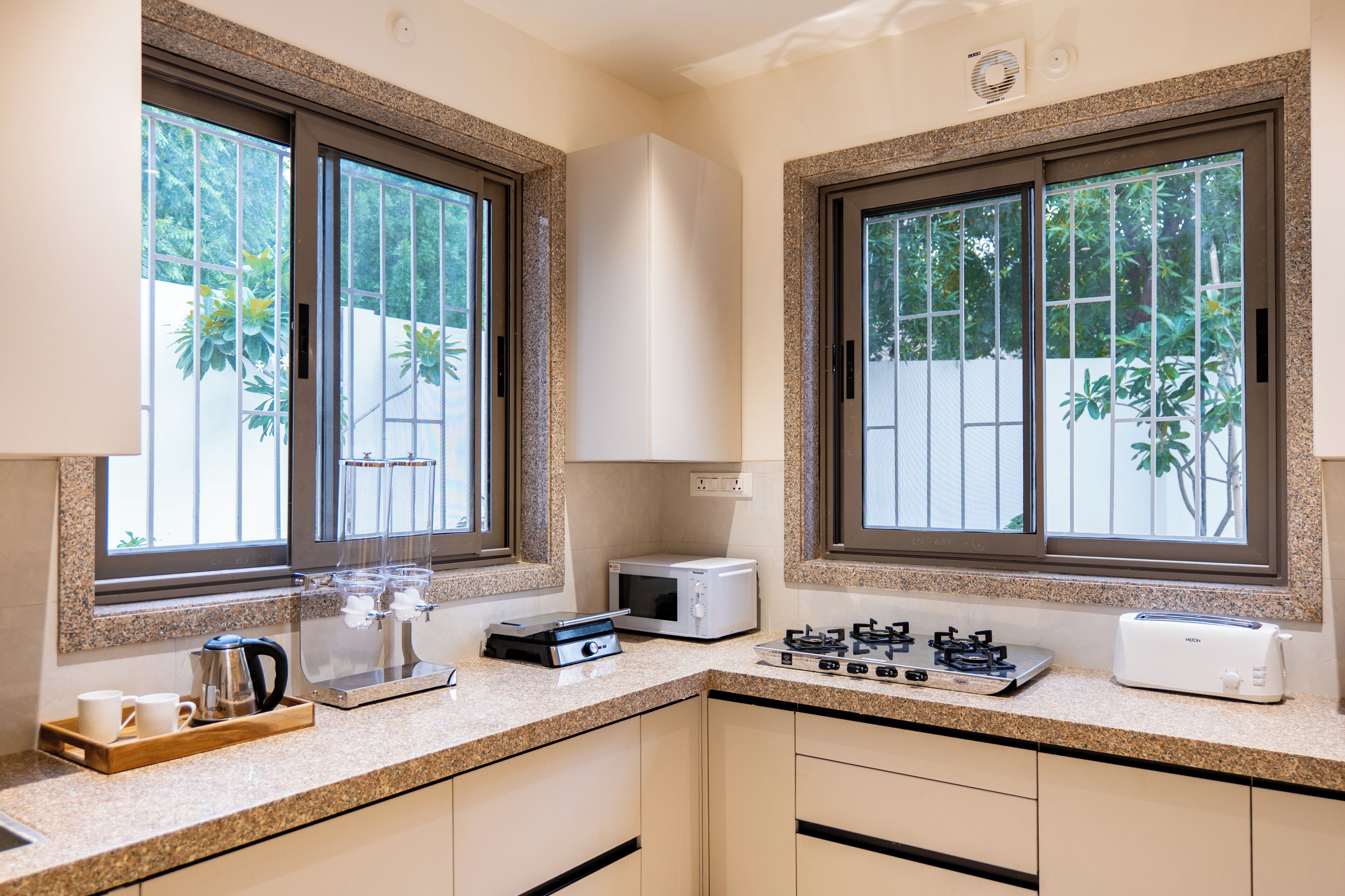 A kitchen with granite countertops, a toaster, a kettle, and a coffee machine.