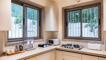A kitchen with granite countertops, a toaster, a kettle, and a coffee machine.