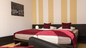 Een hotelkamer met een bed, nachtkastje, stoel en een aan de muur hangend schilderij.