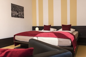 A hotel room with a bed, a bedside table, a chair, and a wall-mounted picture. - TOP Embrace Hotel Grenzfal (Berlin)