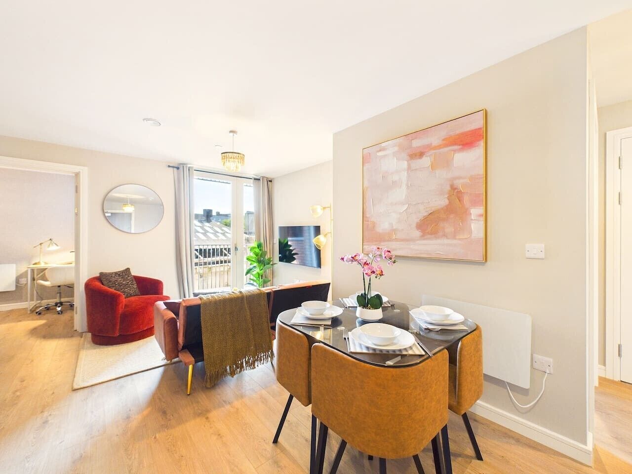 A dining area with a round table, chairs, and a vase of flowers.