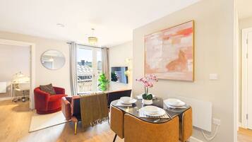 A dining area with a round table, chairs, and a vase of flowers.