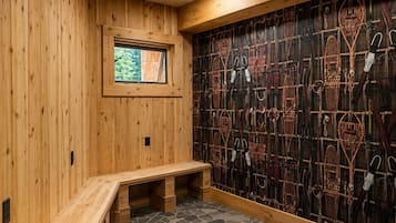 Une pièce en bois avec un banc, une fenêtre et un mur orné de divers objets.