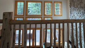 A room with a sloped ceiling, a ceiling fan, and multiple windows with wooden frames. - Luxury Stowe Retreat Sleeps 18 Hot Tub & Mtn Views (Stowe)