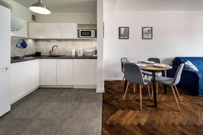 Cozinha moderna com armários brancos, micro-ondas e pia.