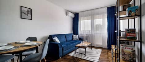 A modern living room with a sofa, coffee table, and a bookshelf.