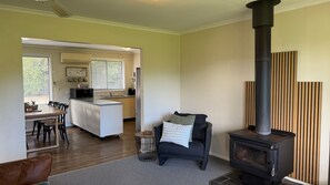 Un espacio de sala acogedor con chimenea, una mesa de comedor con sillas y una cocina al fondo.