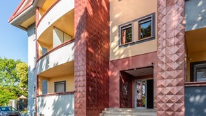 Ein mehrgeschossiges Gebäude mit einer geschwungenen Fassade, Balkonen und einem zentralen Eingang.